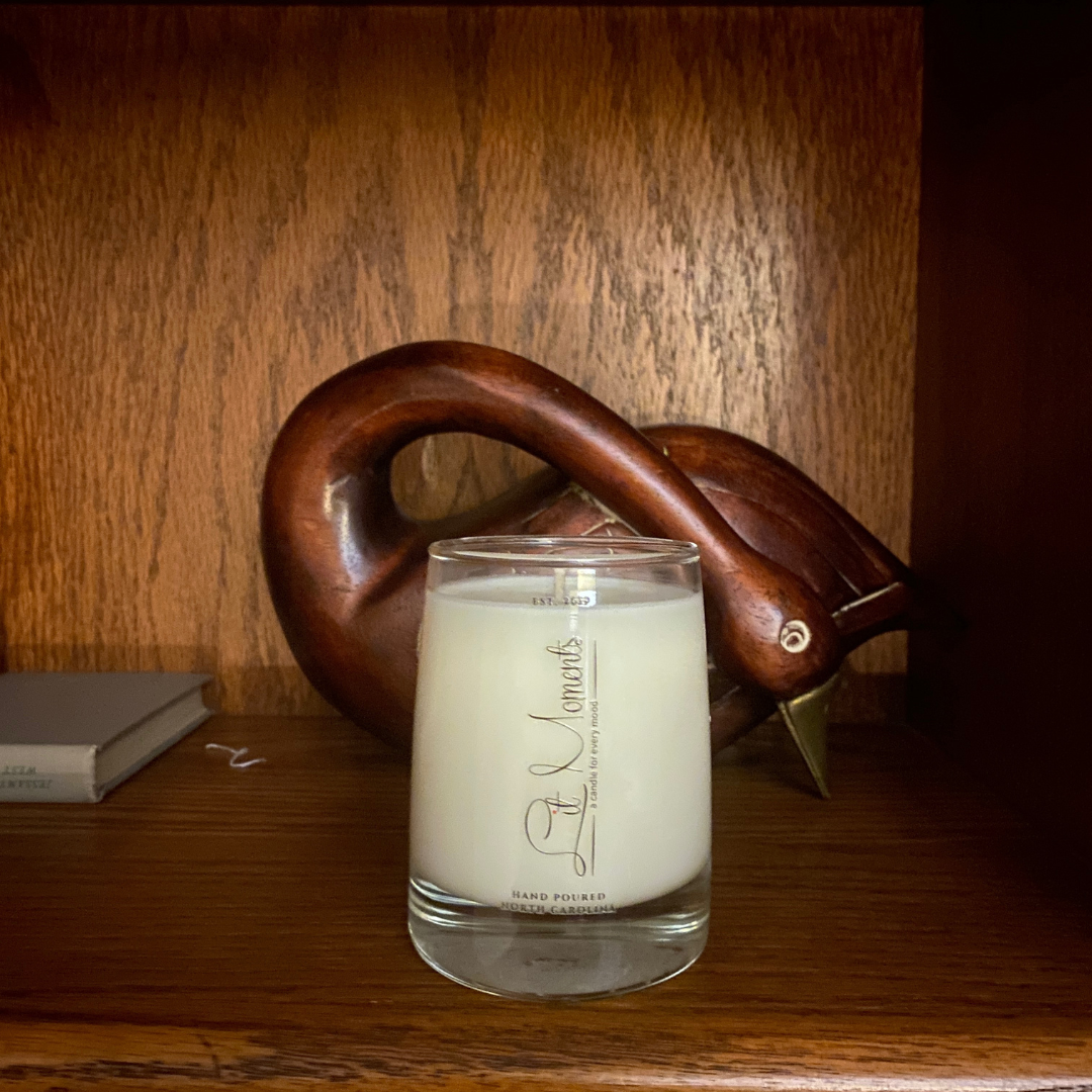 A hand-poured luxury candle from Lit Moments Candle Company, displayed in a sleek glass jar with a minimalist label, designed to elevate home decor.