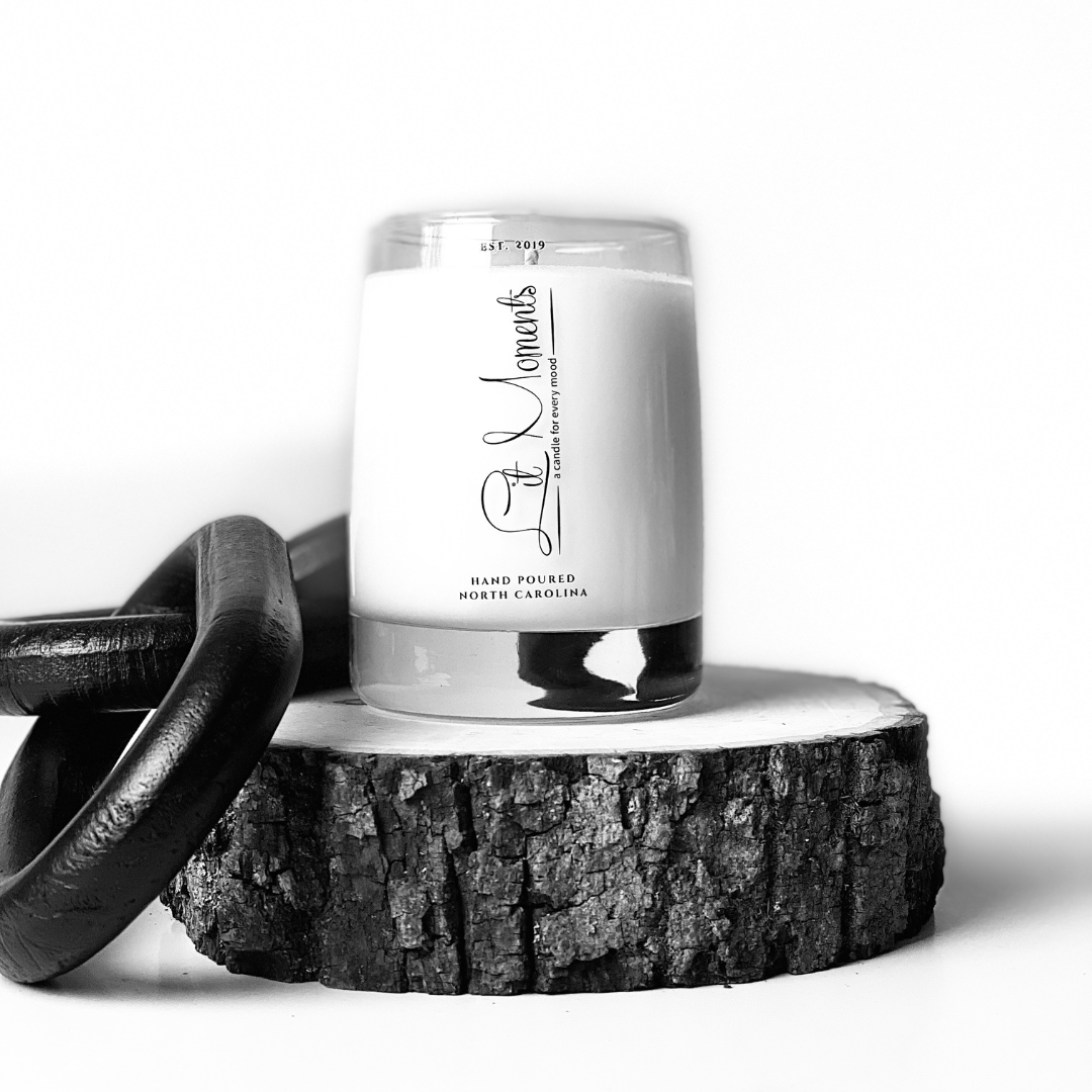 A hand-poured luxury candle from Lit Moments Candle Company, displayed in a sleek glass jar with a minimalist label, designed to elevate home decor.